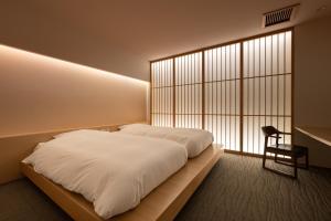 - une chambre avec un grand lit blanc et une fenêtre dans l'établissement Shaga-no-Sato Yumeya, à Niigata