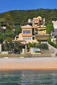dom na wzgórzu obok wody w obiekcie Sivota Seascape Luxury Villas & Residences w mieście Sivota