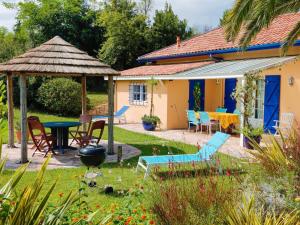 アングレットにあるVilla in France near Beach & Private Poolのパティオ、テーブル、椅子が備わる家