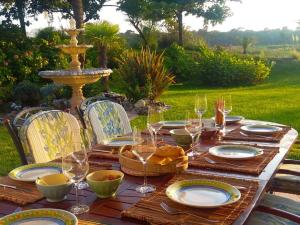 een houten tafel met borden en glazen en een fontein bij Gorgeous Villa in Anglet with Swimming Pool in Anglet