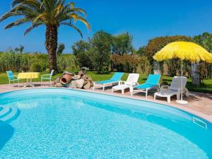 - une piscine avec des chaises et des parasols à côté d'un palmier dans l'établissement Gorgeous Villa in Anglet with Swimming Pool, à Anglet