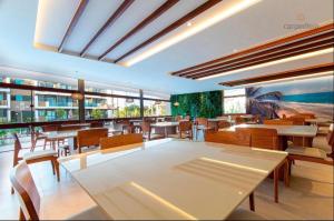 un restaurante con mesas y sillas en una habitación en Porto Beach Resort - Mana Beach Experience, en Porto de Galinhas