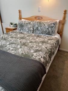 een bed met een zwart-witte deken en kussens bij Carly’s Place in Rotorua