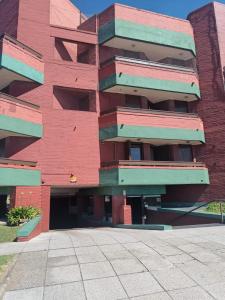 un edificio de ladrillo rojo con balcones. en Departamento 2 ambientes frente al mar con cochera en Mar del Plata