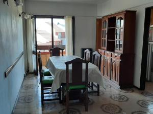 comedor con mesa, sillas y ventana en Departamento 2 ambientes frente al mar con cochera en Mar del Plata