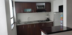 a small kitchen with a sink and a refrigerator at Apartamento La Floresta con todas las comodidades in Bogotá