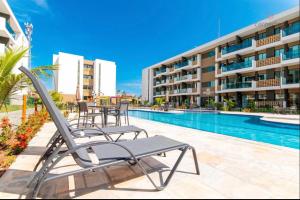 basen z leżakami i budynkiem w obiekcie Porto Beach Resort - Mana Beach Experience w mieście Porto de Galinhas