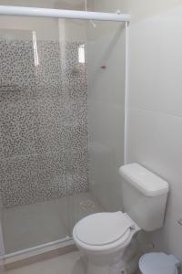 a white bathroom with a toilet and a shower at Hotel hawaii in Campos dos Goytacazes