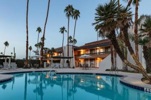 a hotel with a swimming pool and palm trees at Travelodge by Wyndham Palm Springs in Palm Springs