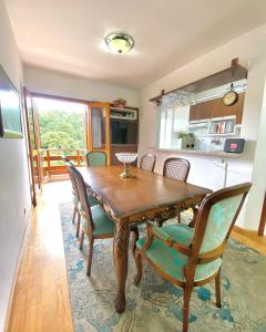 - une salle à manger avec une table et des chaises en bois dans l'établissement Duplex Vista da Serra, à Campos do Jordão