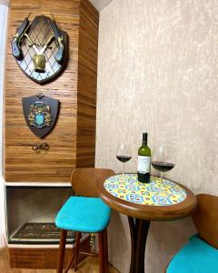 une table avec deux verres de vin et une horloge dans l'établissement Duplex Vista da Serra, à Campos do Jordão