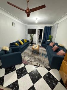 uma sala de estar com sofás azuis e um piso xadrez em Appartement à Miami - Vu sur mer em Alexandria