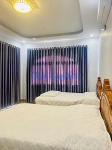 1 Schlafzimmer mit 2 Betten vor einem Fenster in der Unterkunft Nhà Nghỉ Blue Sapphire - hotel in Xuyên Mộc