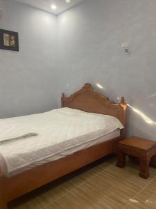 Schlafzimmer mit einem Bett mit einem Kopfteil aus Holz und einem Tisch in der Unterkunft Nhà Nghỉ Blue Sapphire - hotel in Xuyên Mộc