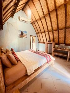 a bedroom with a bed in a room with wooden ceilings at Apit Lawang Villas & Resto in Nusa Penida +65 photos