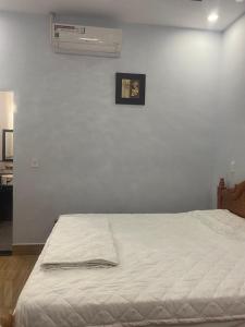 1 Schlafzimmer mit einem weißen Bett und Klimaanlage in der Unterkunft Nhà Nghỉ Blue Sapphire - hotel in Xuyên Mộc