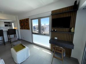 sala de estar con TV y ventana grande en Apart en San Telmo- Paseo de la Cisterna- 1228 en Buenos Aires