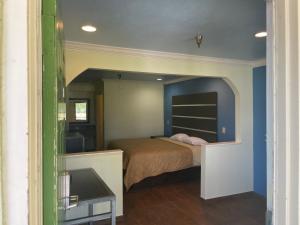 a bedroom with a bed in a room with blue walls at Mustang inn in Jackson