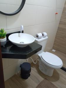 Łazienka z białą toaletą i umywalką w obiekcie Flat Container Pontal do Atalaia w mieście Arraial do Cabo