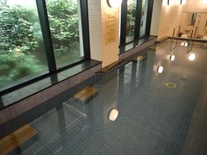 a lobby with windows and a tiled floor with lights at Hotel Nikko Nara in Nara