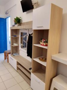 a walk in closet with white shelves and a tv at Studios Prevena in Adamantas