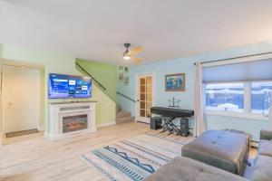 a living room with a television and a piano at The Garay Townhome w/Contemporary Vibes in Fairbanks