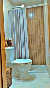 a bathroom with a toilet and a shower at Japaratinga Suites in Japaratinga