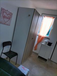 Habitación pequeña con silla y ventana en Mini liquirizia e menta en Reggio Emilia