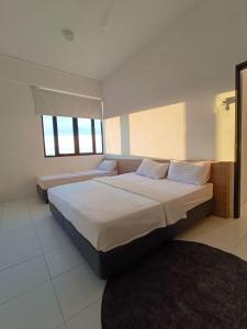 een slaapkamer met een groot bed en een raam bij Azfa Imperio Professional Suite Alor Setar in Alor Setar