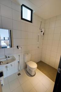 een witte badkamer met een toilet en een wastafel bij Azfa Imperio Professional Suite Alor Setar in Alor Setar