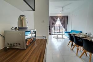 a kitchen with a microwave and a table with chairs at Azfa Imperio Professional Suite Alor Setar in Alor Setar