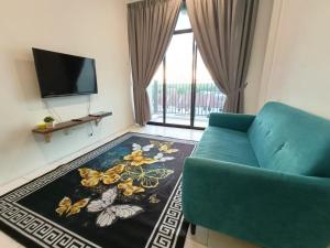 een woonkamer met een blauwe bank en een televisie bij Azfa Imperio Professional Suite Alor Setar in Alor Setar