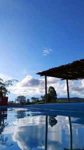 un pozzetto d'acqua con un padiglione sullo sfondo di Chalés Bela Vista a São Thomé das Letras