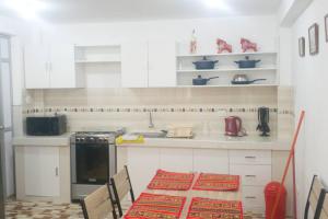 a kitchen with a table and a stove top oven at Cusco Central Aparment in Cusco
