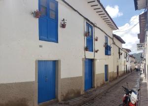 un edificio con puertas azules y un scooter aparcado en una calle en Cusco Central Aparment, en Cusco