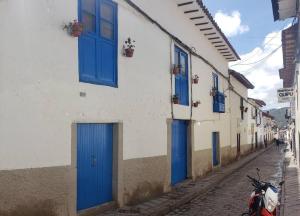 budynek z niebieskimi drzwiami i skuterem zaparkowanym na ulicy w obiekcie Cusco Central Aparment w Cuzco
