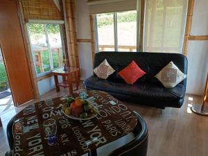 a living room with a couch and a table with a bowl of fruit at Cabaña independiente en Granja Agroecologica in Anolaima