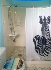 a bathroom with a zebra drawn on the shower curtain at Gialyn's Bed and Breakfast in Loon