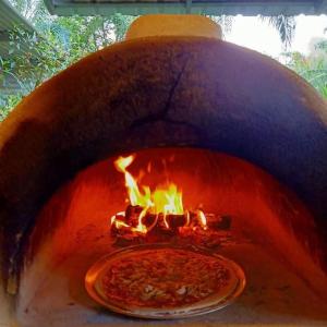 una pizza dentro de un horno con una pizza dentro en Koom Kachanaan en Ban Nong Thale