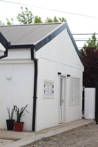 un garaje blanco con techo negro en Pueblo Dorado Departamentos en Malargüe