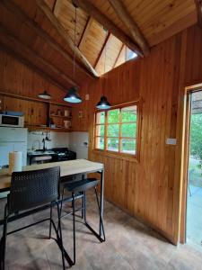 una cucina con pareti in legno, tavolo e sedie di Complejo Ermitazh a Valle Grande