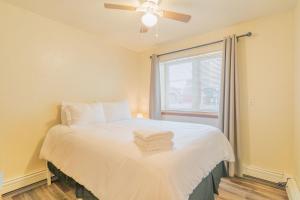 a bedroom with a bed with a ceiling fan and a window at 28th Ave Unit2 Centrally Located Coffee Bar and Comfort in Fairbanks
