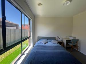 庫克角的住宿－Point Cook Private Room，一间卧室设有一张床和一个大窗户