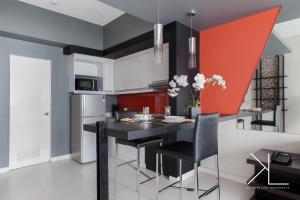 a kitchen with a black table and black chairs at KL Serviced Residences Managed by HII in Manila
