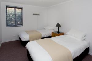een slaapkamer met 2 bedden en een raam bij Hunter Valley Retreat in Quorrobolong