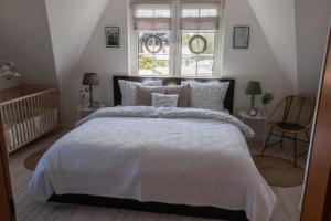 Un dormitorio con una gran cama blanca y una ventana en See Land Luft, en Warnitz