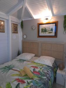a bedroom with a bed with a tropical blanket at La Suite Odile Piscine in Le Lamentin