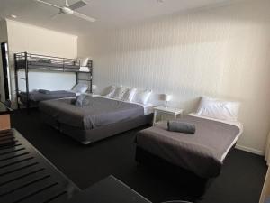 - une chambre d'hôtel avec 2 lits et des lits superposés dans l'établissement Albert Park Motor Inn-KING BEDS-POOL-SHADED PARKING, à Longreach