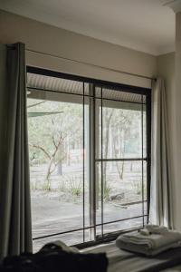 Schlafzimmer mit einem Fenster mit Blick auf den Hof in der Unterkunft Hunter Valley Retreat in Quorrobolong