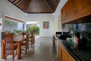 坎古的住宿－My Villa and Resort Canggu，一间带木桌的厨房和一间餐厅